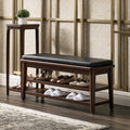 Dark wood shoe bench with black leather cushioned top, perfect for entryway storage and seating, by PedestalDiningCo.
